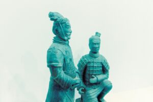 Two ancient terracotta warrior statues in a museum setting.