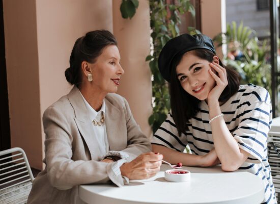 Person chopping green herbs on a cutting board in kitchen.