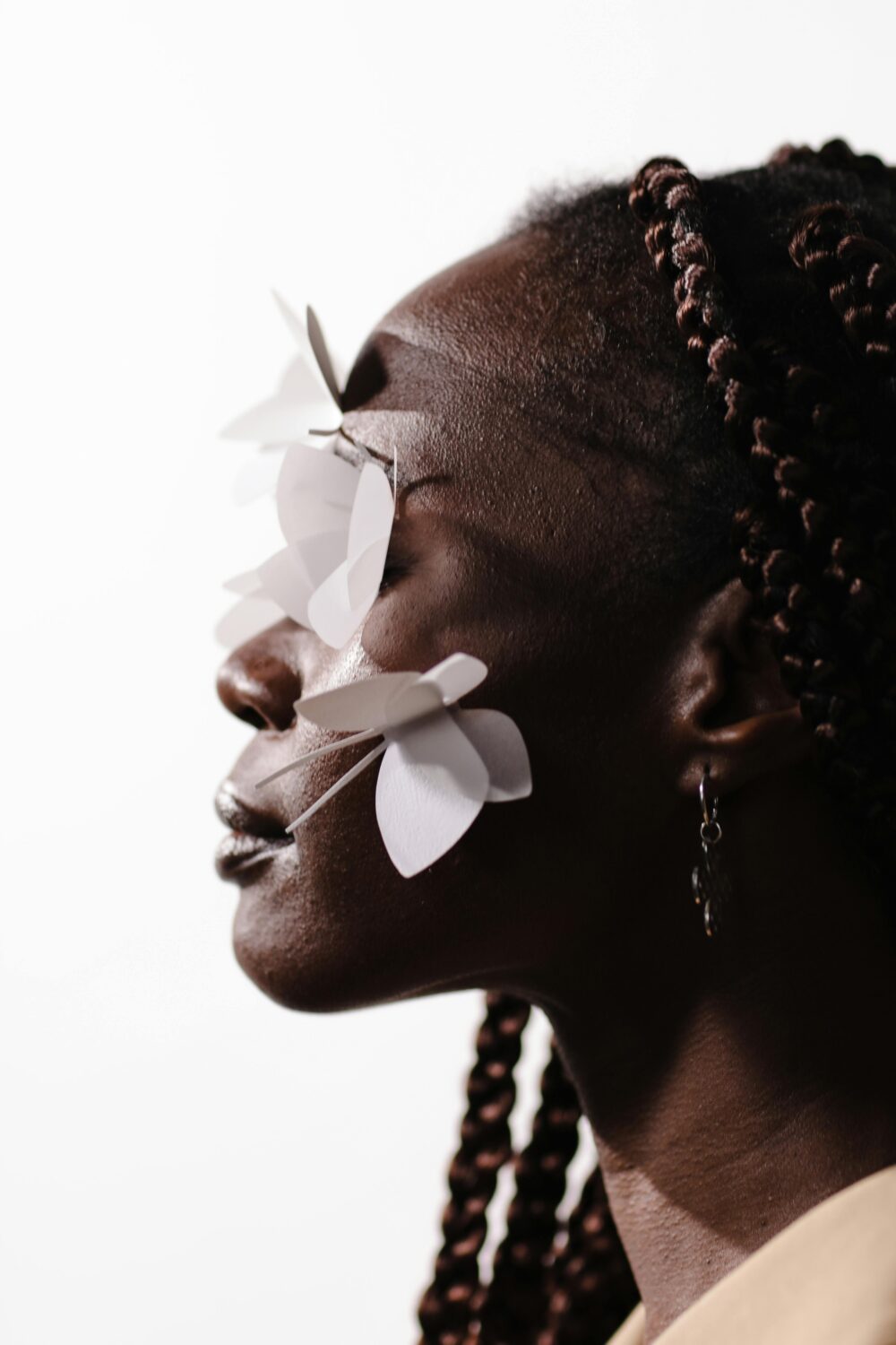 Profile of person with paper butterflies on their face.