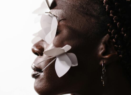 Profile of person with paper butterflies on their face.