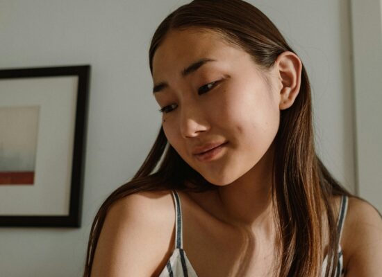 Person in striped top, soft lighting, framed art on wall.