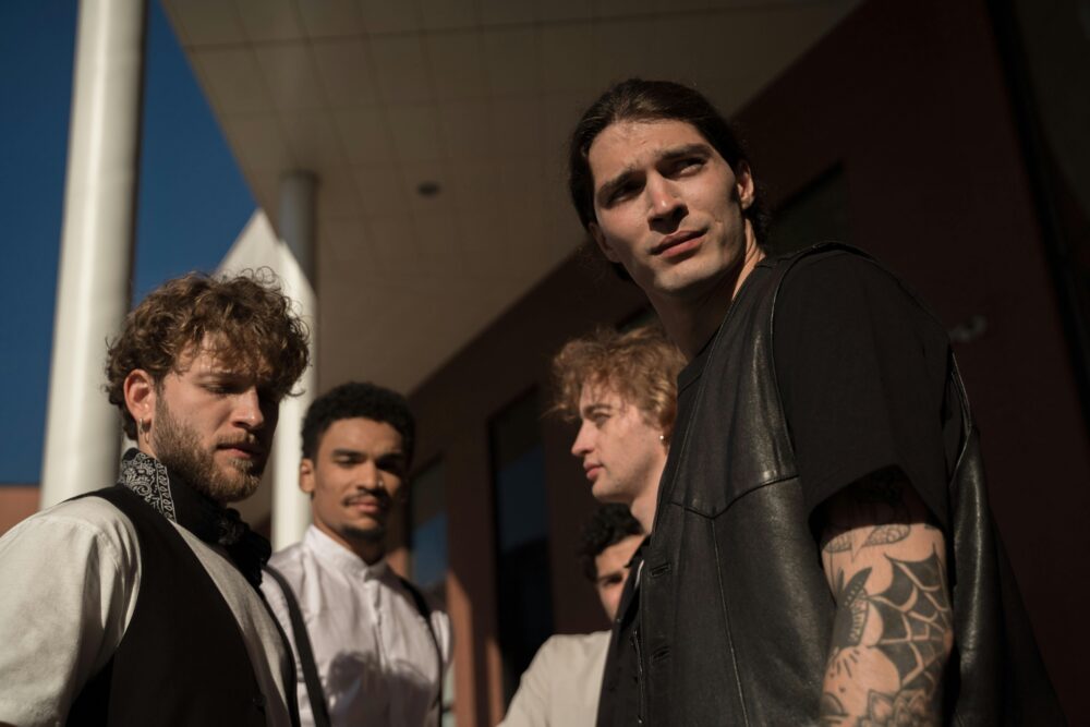 A group of young men stand outside a modern building.