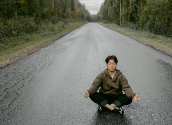 A dark sphere surrounded by swirling white smoke on black background.