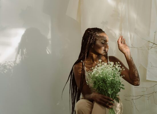 Person holding bouquet of flowers, surrounded by soft natural light.