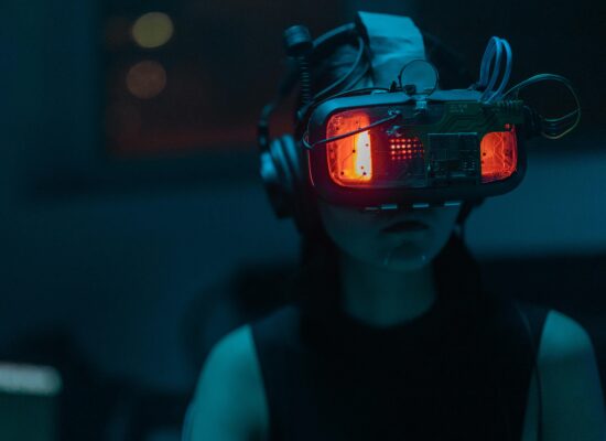 Person wearing futuristic VR headset with glowing red lights.