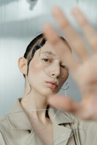 A person with wet hair and wire art on their face.