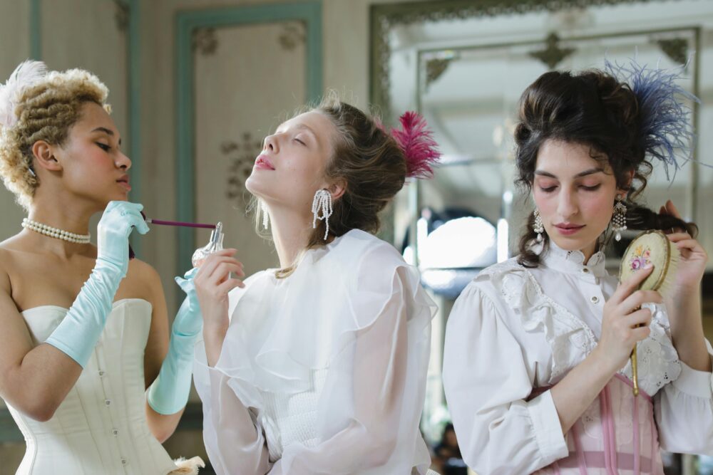 Three women in vintage attire preparing for an event.
