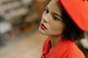 A person wearing a red beret and jacket, looking away.