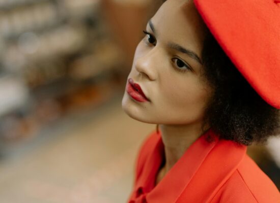 A person wearing a red beret and jacket, looking away.