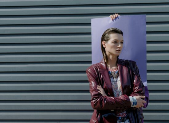 Person holding a purple board in front of a grey wall.