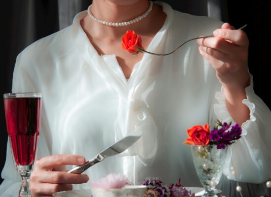 Person in white shirt sitting, pinching nose, looking stressed.