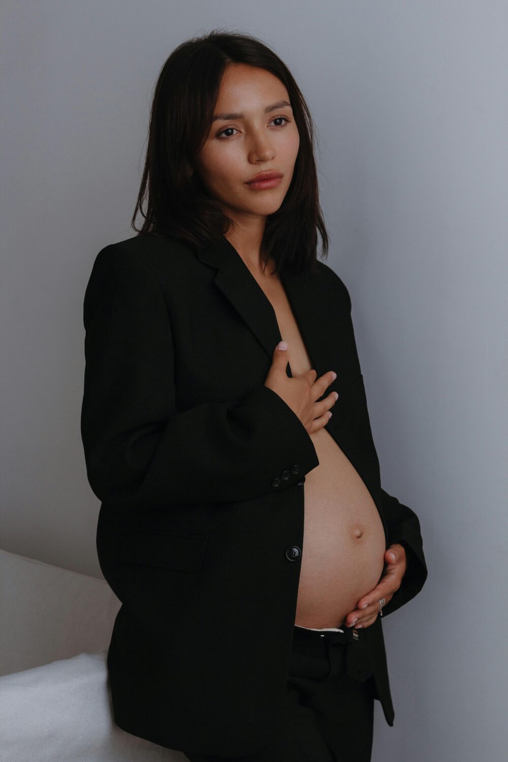 Person lounging on wooden chair, holding mirror, brown background.