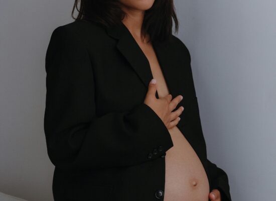 Person lounging on wooden chair, holding mirror, brown background.