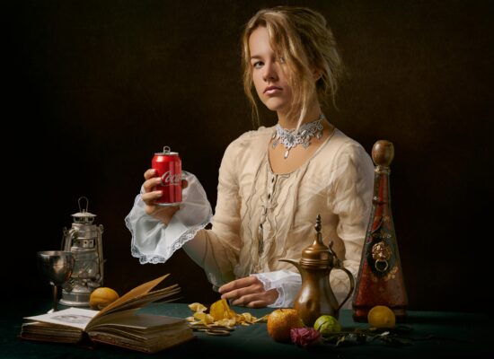 Person in vintage attire holding a Coca-Cola can, surrounded by antiques.