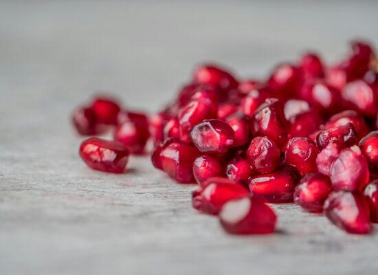 Close-up of fresh pomegranate seeds scattered on a surface.
