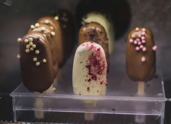 Assorted chocolate and vanilla ice cream bars with colorful toppings.