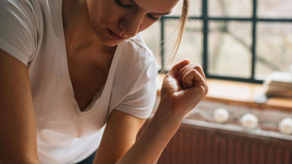 Person giving a massage in a bright, cozy room setting.