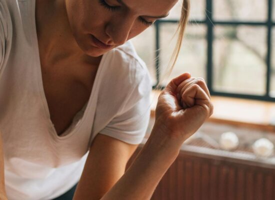 Person giving a massage in a bright, cozy room setting.