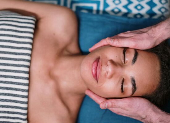 Person receiving a relaxing facial massage, eyes closed, peaceful atmosphere.