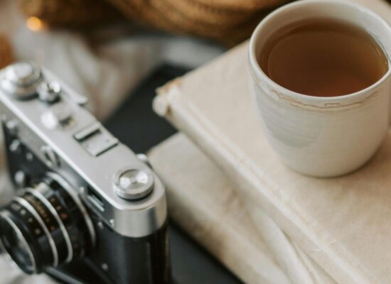 Cup of tea, books, vintage camera, cozy blanket, walnuts.