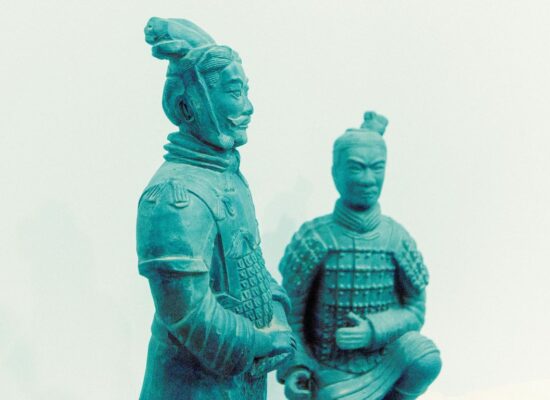 Two ancient terracotta warrior statues in a museum setting.