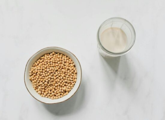 Bowl of soybeans and glass of soy milk on table.