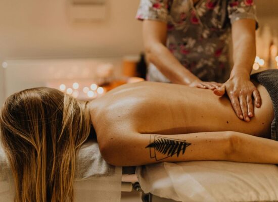 Person receiving a relaxing back massage in a cozy setting.